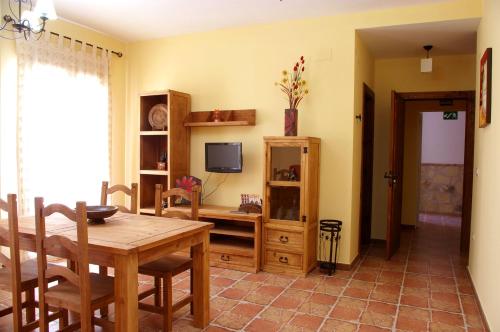 a dining room with a table and a television at Villa de Xicar in Montejicar