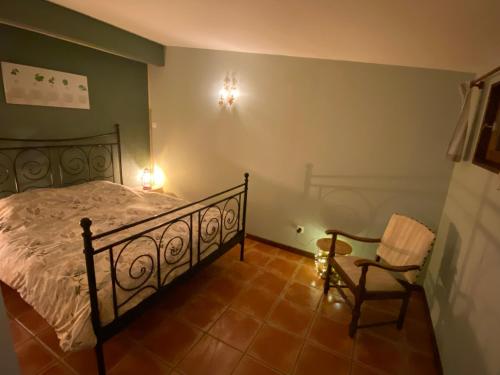 una camera da letto con un letto e una sedia di Gite Deja Vu a Montcabrier
