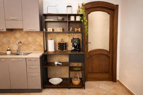 una cucina con lavandino e porta in legno di Le Stanze Della Castellana a Bosa