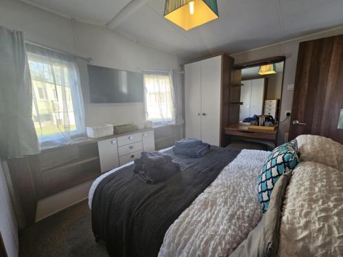 a bedroom with a bed and a sink and windows at The Suite in Tosside