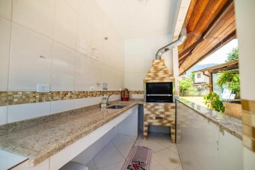 una grande cucina con lavello e camino di Pousada Cantinho do Sossego Paraty tem Piscina com Vista pra Montanha, Salão de Jogos, Café da Manhã, Estacionamento, Gerador de Energia, Próximo as principais Praias, Ilhas e Cachoeiras a Parati