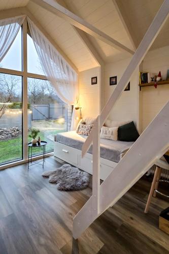 a bedroom with a bed and a large window at Namiņš atpūtai in Liepāja