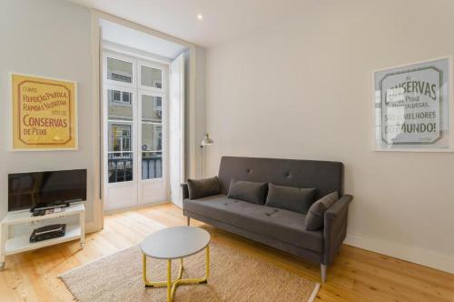 a living room with a couch and a tv at Residencial Neves - Baixa in Lisbon