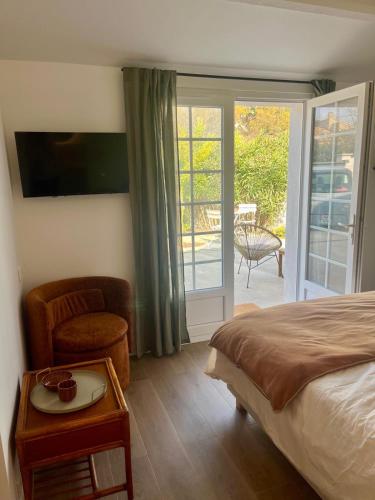 a bedroom with a bed and a sliding glass door at Logement neuf climatisé calme proche Arena Sud de France in Pérols