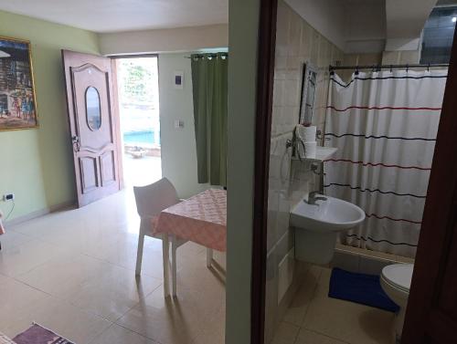 a bathroom with a sink and a toilet and a door at Hotel Don Michele in Boca Chica