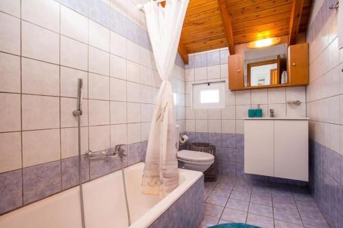 un bagno con vasca, WC e doccia di MEGAT SEAVIEW AND SEASIDE APARTMENTs a Ialyssos