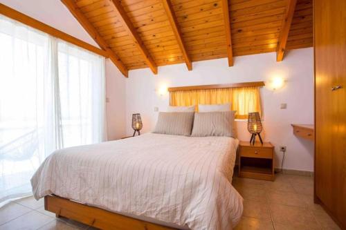 una camera da letto con un grande letto con due lampade sopra di MEGAT SEAVIEW AND SEASIDE APARTMENTs a Ialyssos