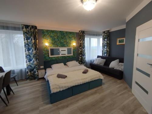 ein Schlafzimmer mit einem großen Bett und einer Couch in der Unterkunft Malownicze Owieczki 