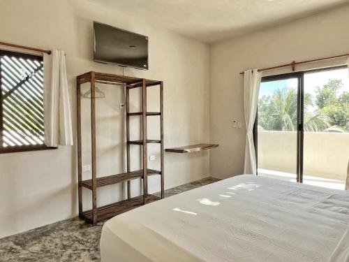 a bedroom with a bed and a large window at Hotel Lydna Ki'n in Bacalar