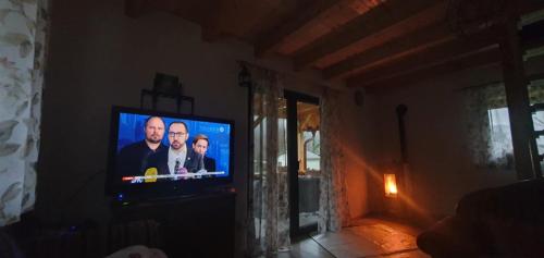 een televisie met twee mannen erop in een woonkamer bij Duric in Cazin