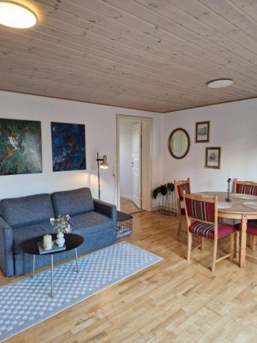 a living room with a blue couch and a table at Lejlighed i Gråsten in Gråsten