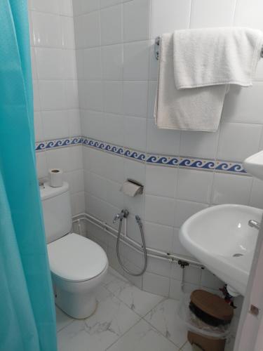 a bathroom with a toilet and a sink at Hôtel Ennassim in Sousse