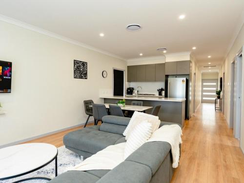 a living room with a couch and a table at Hunter Valley Modern 4-Bedroom House in North Rothbury