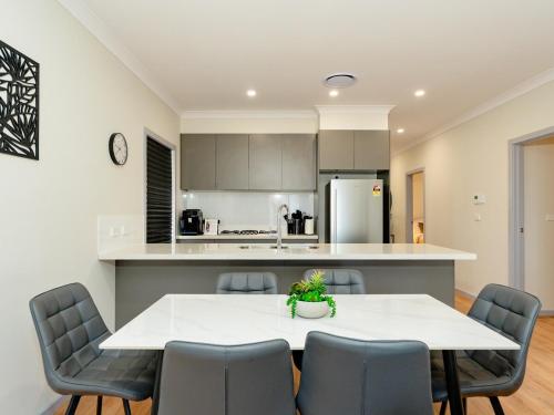 a kitchen and dining room with a table and chairs at Hunter Valley Modern 4-Bedroom House in North Rothbury