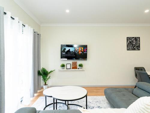 a living room with a couch and a table at Hunter Valley Modern 4-Bedroom House in North Rothbury