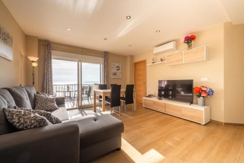 ein Wohnzimmer mit Sofa und Fernseher in der Unterkunft Apartamento Las Góndolas Playa ALOJAMIENTOS VISTAMAR in Almuñécar