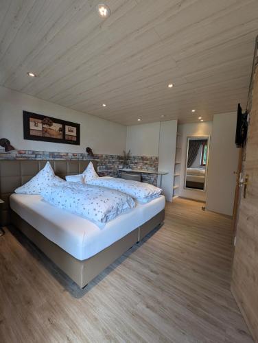 a bedroom with a large white bed in a room at Apartments Fischerklause am Bodensee in Wasserburg