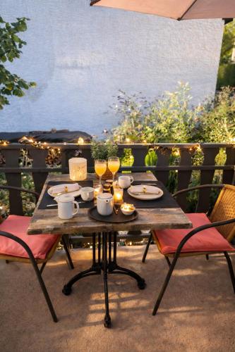 une table en bois avec des verres de vin sur une terrasse dans l'établissement Pension zur Quelle, à Deudesfeld