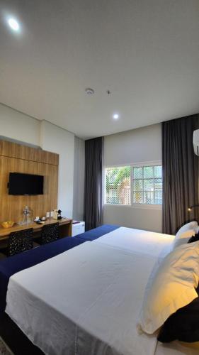 a large bedroom with a large bed and a desk at Granja Brasil puc 10 2 in Petrópolis