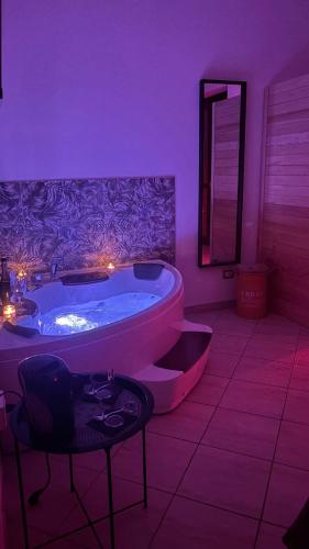 a purple bathroom with a tub and a table at Harmony Boutique inn in Bassano Romano