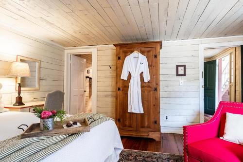 ein Schlafzimmer mit einem weißen Bademantel, der an einer Wand hängt in der Unterkunft Glen-Ella Springs Hotel & Restaurant in Clarkesville