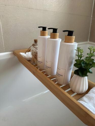 a group of four bottles on a shelf in a bathroom at The Imperial Beachfront Penthouse Suite in Margate