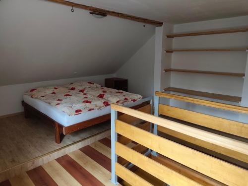 une petite chambre avec un lit et un escalier dans l'établissement Apartmán Bára, à Tanvald