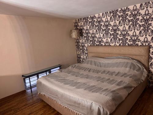 a bedroom with a bed with a black and white wallpaper at Квартира in Chişinău