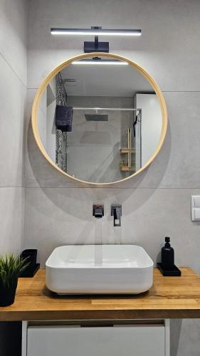 a bathroom with a white sink and a mirror at Domki Pod Lasem - Domek Bukowy in Stronie Śląskie