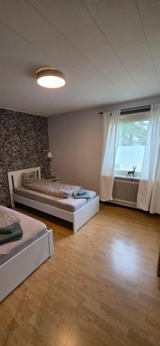 two beds in a room with a large window at Villa Kjell in Vidsel