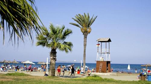 een strand met palmbomen en mensen op het strand bij Marble Coast Studio Apartment in Larnaka