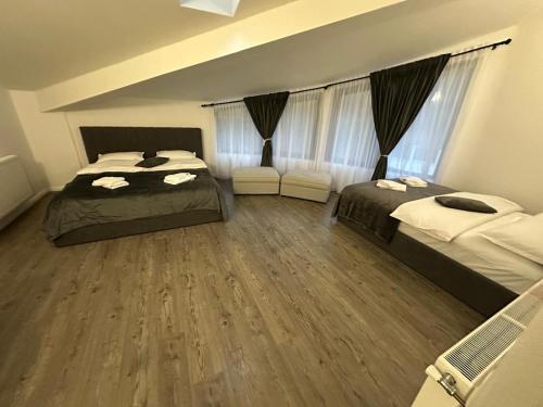 a bedroom with two beds and a wooden floor at Vila Liana in Stana
