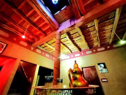 una habitación con una mesa con un jarrón en ella en Gite le Calme café Restaurant Pizzeria, en Bou Drarar