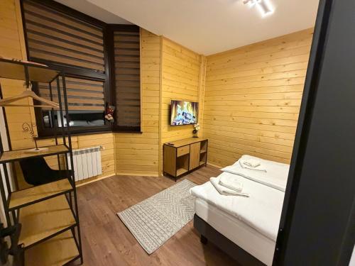 a small room with a bed and a television at Flora Hotel Apartment 103 in Borovets