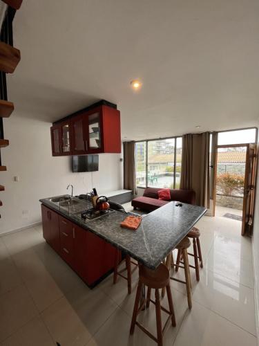 uma cozinha com armários vermelhos e uma bancada em La Quebrada lodge em Papudo