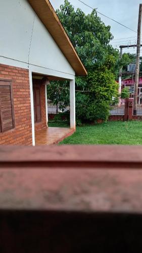 a brick house with a porch and a yard at Alojamiento céntrico in Puerto Iguazú