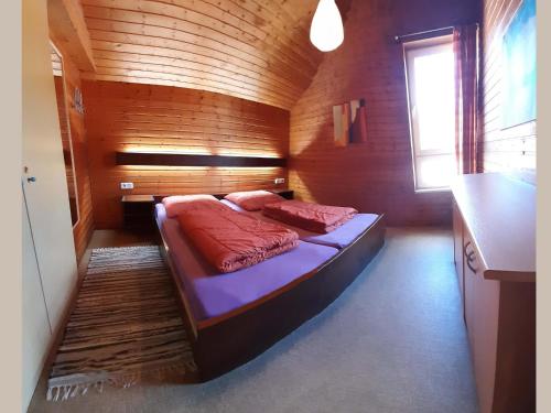 a small bedroom with a bed in a wooden room at Geraeumiges Apartment mit privater Terrasse in Schmallenberg
