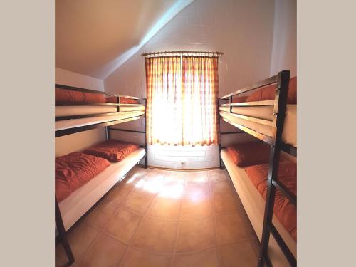 a room with three bunk beds and a window at Charmantes Ferienhaus in Skigebietsnähe in Schmallenberg