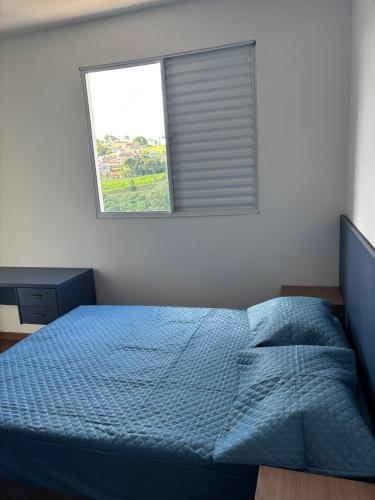 a bedroom with a blue bed and a window at Blue da Mantiqueira in Extrema
