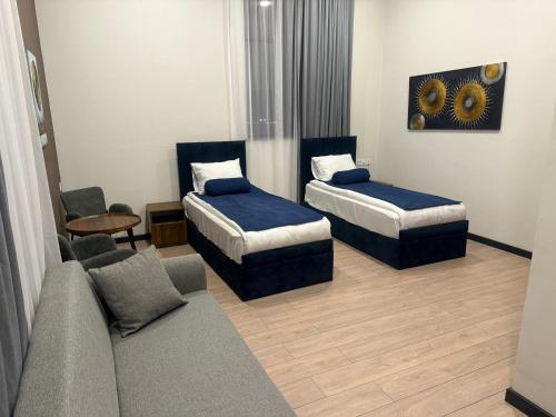 a hotel room with two beds and a couch at LIFESPORT-Complex Hotel & spa in Əlǝt