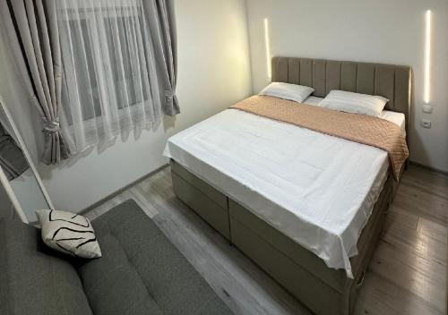 een kleine slaapkamer met een bed en een raam bij Centar Posušje Jednosobni stan in Posušje