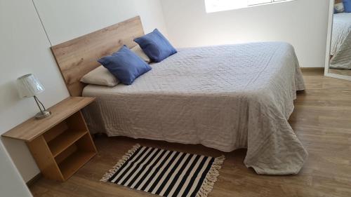 ein Schlafzimmer mit einem Bett mit blauen Kissen in der Unterkunft Departamento Centrico Yanahuara Beaterio in Arequipa