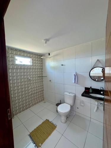 ein weißes Badezimmer mit Toilette und Spiegel in der Unterkunft Flats Varandas Praia Bela - Apto 103 in Pitimbu