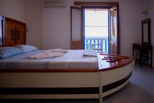 a bedroom with a bed with a view of the ocean at TO VOTSALO-beach side studios & taverna in Karpathos