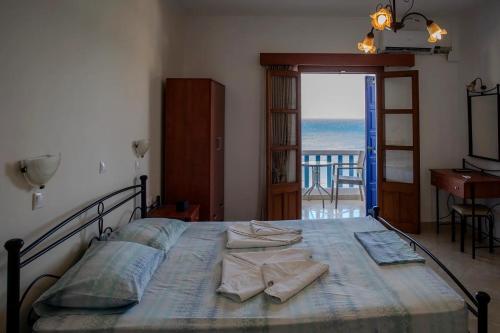 a bedroom with a bed with a view of the ocean at TO VOTSALO-beach side studios & taverna in Karpathos