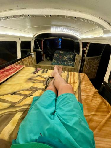 a person laying on a bed in a van at Kombi Home do Jardins in Imbituba