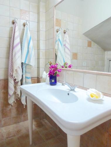 a bathroom with a sink and a mirror and towels at Pentathlon Villa Collection - Porto Cheli Private Pool Getaways in Porto Heli