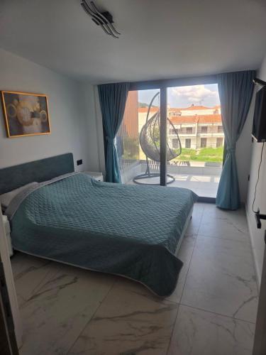 een slaapkamer met een bed en een groot raam bij Sunny Aparts in Polykhrono