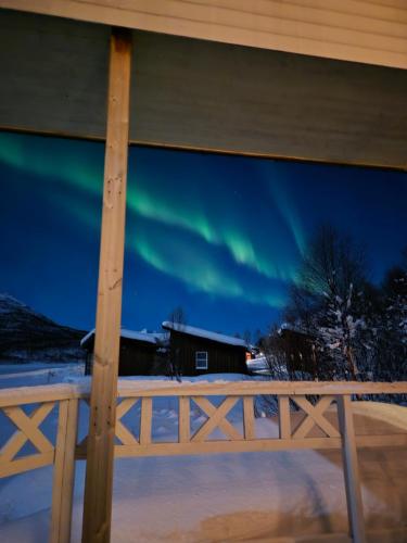 een uitzicht op het noorderlicht door het raam van een huis bij Fjord & Flame in Tromsø