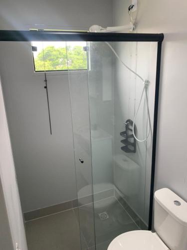 a glass shower in a bathroom with a toilet at Recanto dos Pássaros in Palhoça